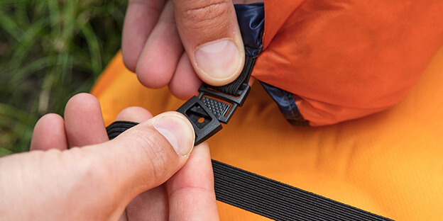a close up of a pad strap connecting to keep a sleeping quilt in place