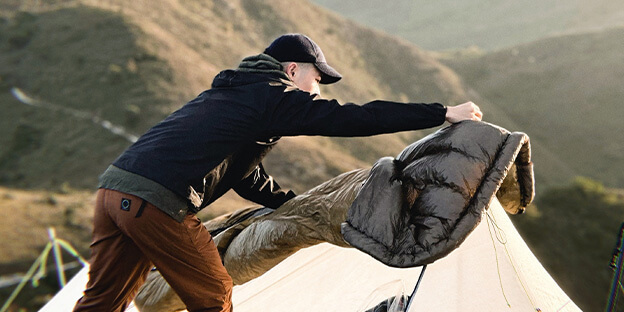 a picture of a man setting up his charcoal quilt to loft up
